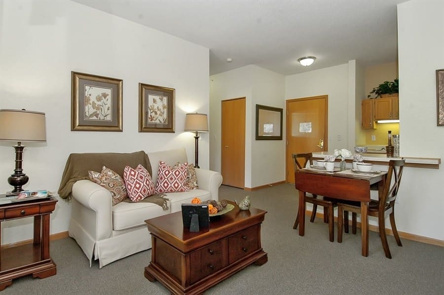 Cozy assisted living apartment interior at Charter Senior Living of Madison, WI, featuring living and dining space with modern furnishings