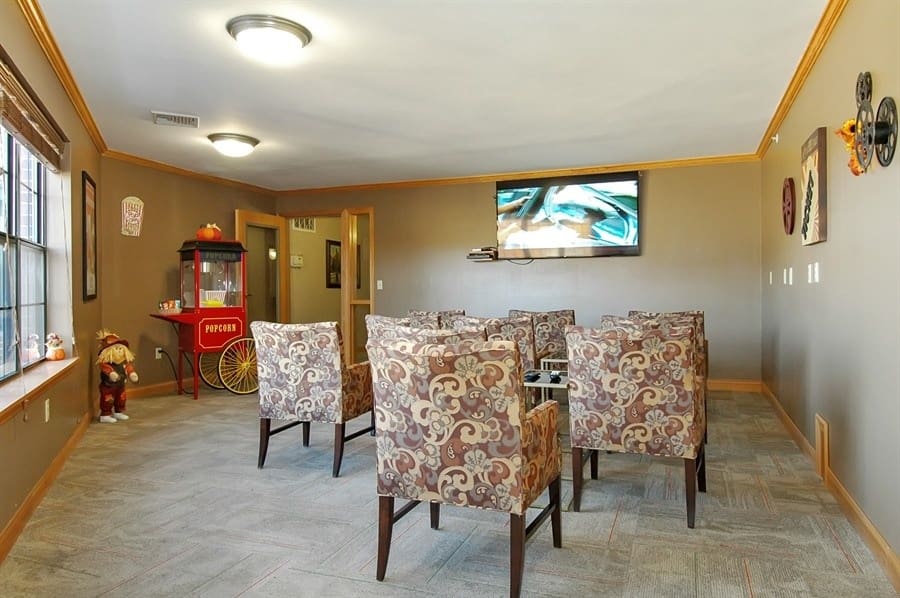 Comfortable activity room at Charter Senior Living of Madison, WI, with armchairs, mounted TV, and popcorn machine for resident gatherings and events